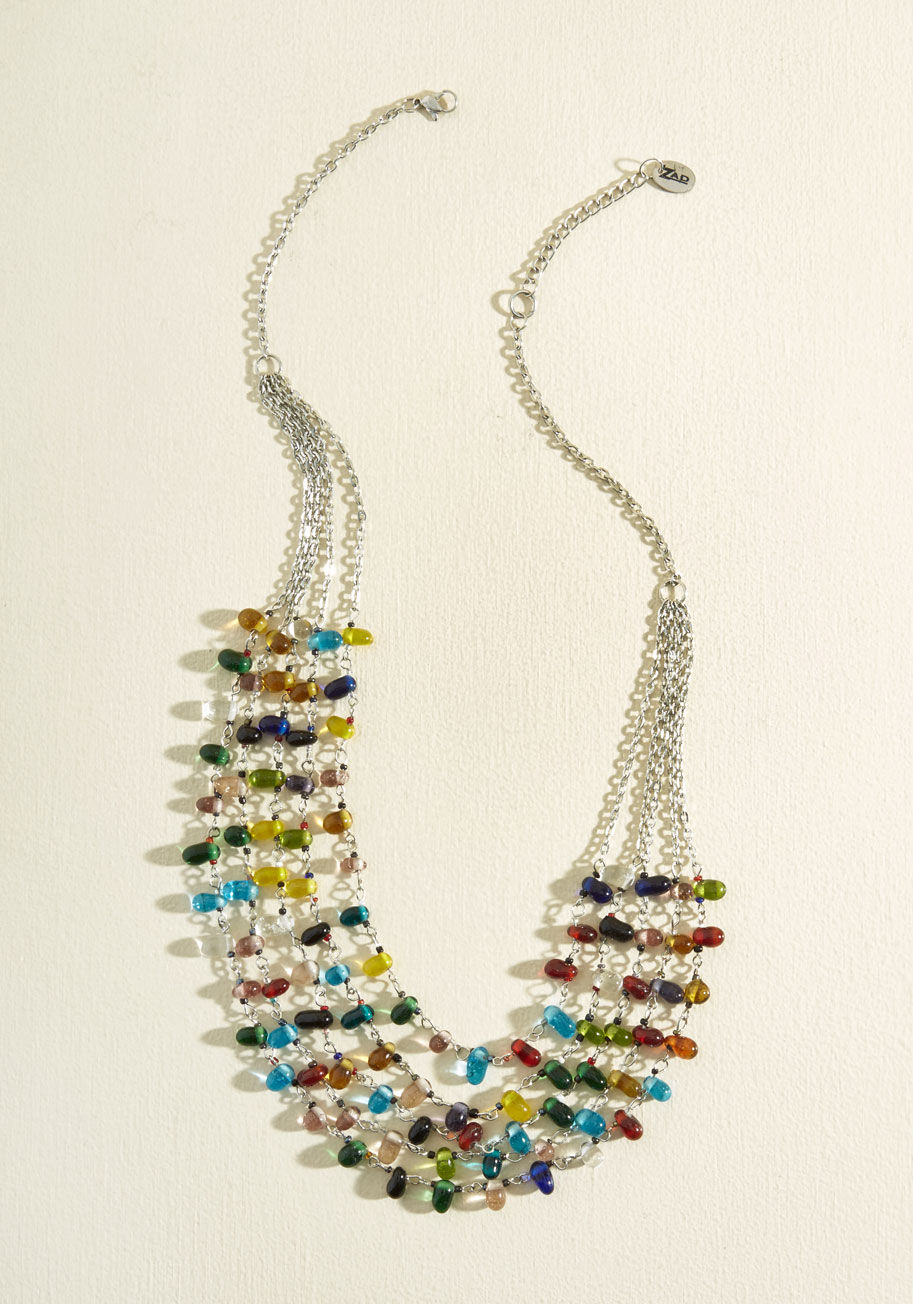  - Accelerate the allure of any ensemble with this colorful statement necklace! Revved up with shining silver chains and an array of prismatic glass beads, this accessory aims to fuel your spirited style