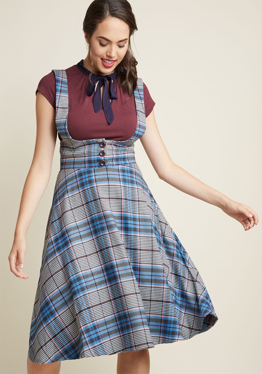  - Feel transported to the styles and sophistication of bygone times with every twirl of this plaid jumper by Collectif! Button-adjusted suspenders support the high waist, hidden pockets, and blue, grey, white, and pink pattern of this woven beauty, creating