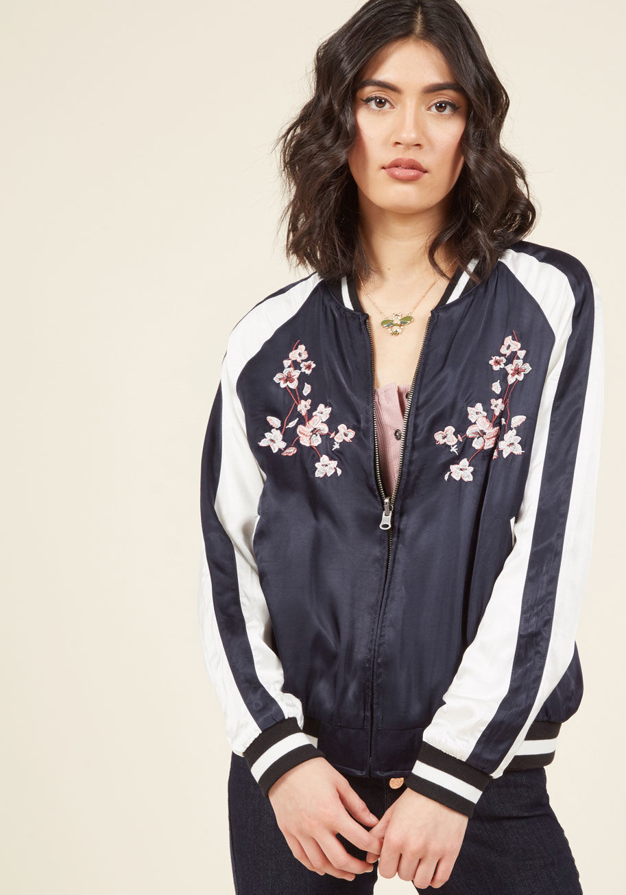  - Kick your day into gear by calling on the fabulous floral embroidery of this jacket to jumpstart an energetic attitude. Boasting a navy blue hue with white accents, black knit trim, and a solid noir reverse, this satiny layer prompts authentic panache!