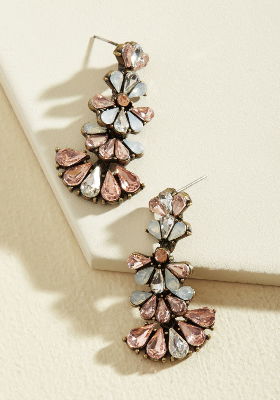  - Once you embrace the boldness these dangling earrings impart upon your look, there's no telling what kind of adventure you'll encounter! Detailed with droplet-shaped rhinestones framed by antiqued gold backings, these petal and silver stunners make a sass