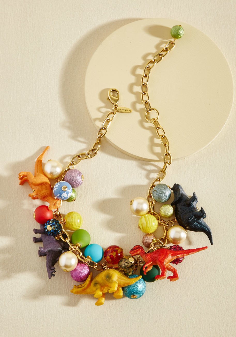  - Put all your energy into accessorizing with this epic necklace! A wonderfully wowing piece by Lenora Dame, this golden chain is charged up with colorful baubles, bold dino figurines, and hella personality.