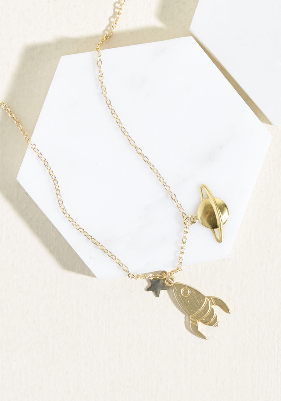  - Some pals do drinks, others take trips. You mark the start of your bestie business endeavor by clasping this Eclectic Eccentricity necklace at your nape! Hanging from a fine cable chain, a gold-plated rocket pendant, silver star, and brass saturn charm ac