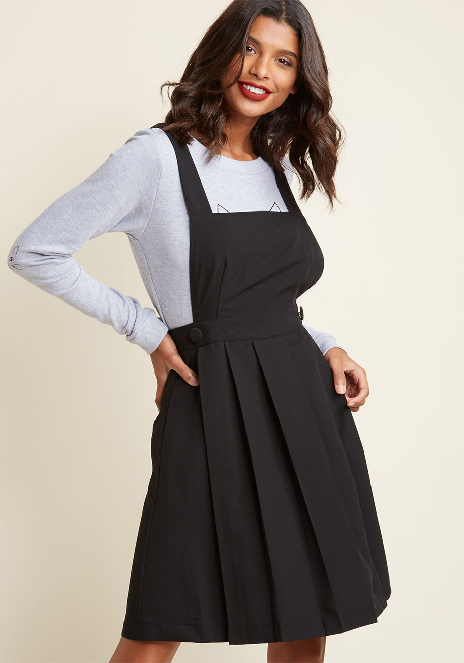  - Sport this black jumper and your enthusiasm for a well-crafted ensemble is sure to shine! Featuring back-crossed straps and a pleated skirt, and accented on the hips by chic covered buttons, this sweet ModCloth-exclusive one-piece helps you dive into styl