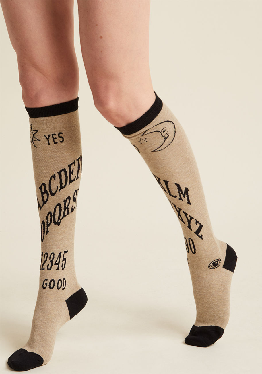  - These tan socks send a memo to the world that you're a spirited being, even when at rest! With black trim and familiar ouija characters printed across the shins, this cozy knee-high pair displays your demeanor loud and clear.