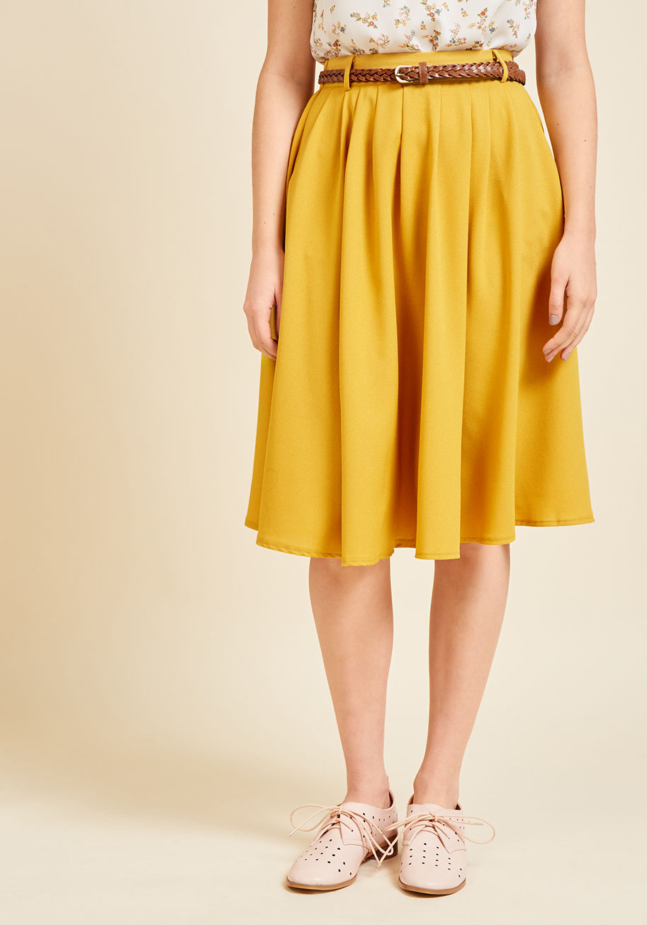 This morning, a bundle of bright flowers was waiting at your door. You excitedly scooped them up, deciding to wear this bright red midi skirt to match their beauty! You clasp the braided faux-leather belt through the loops that sit along the fitted-back w by 