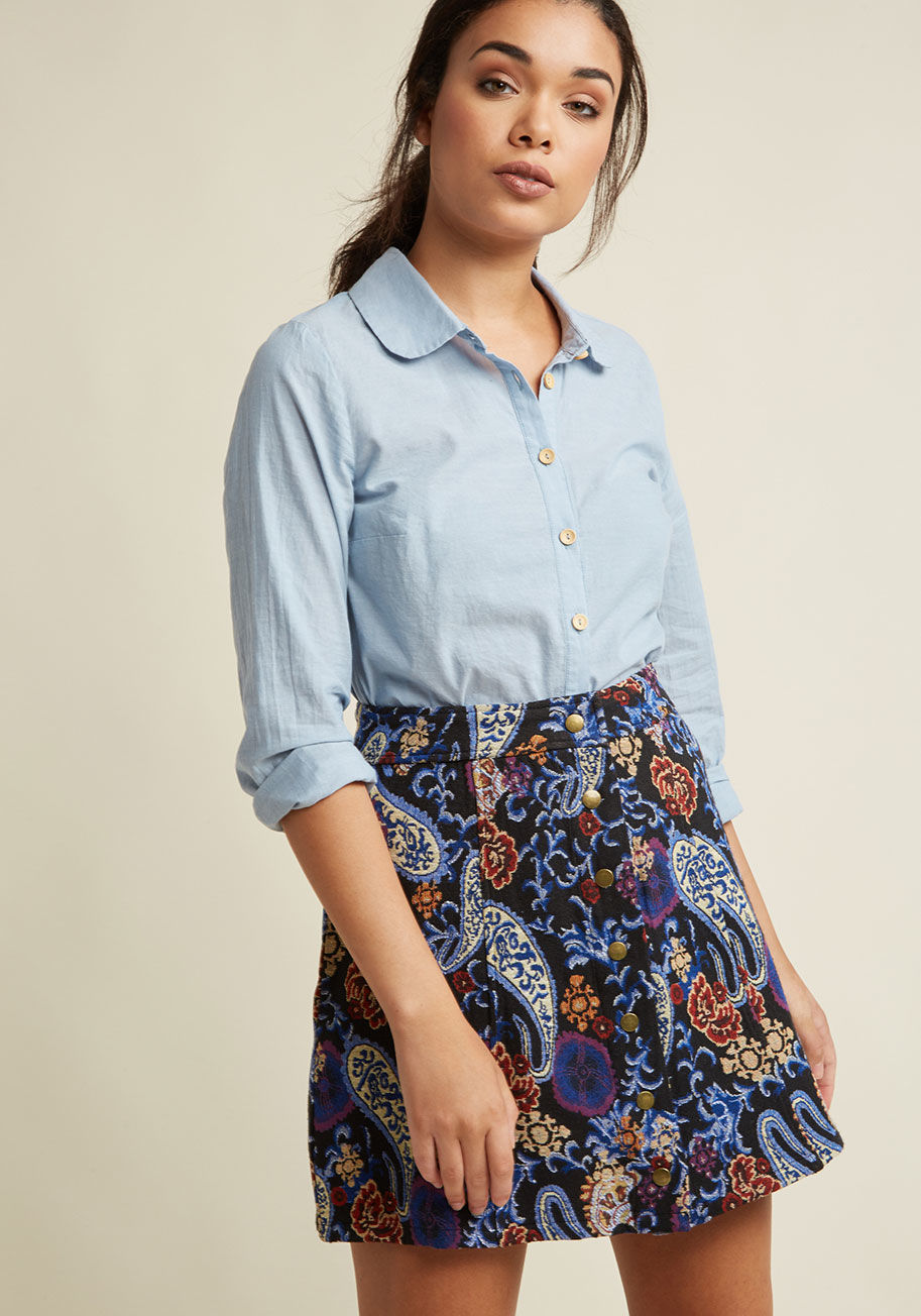  - Wherever you're flaunting this black mini skirt is where we want to be! In addition to its buttoned front, this A-line stunner boasts a gorgeous tapestry motif of blue and white paisley, warm-toned flowers, and icy blue fronds. The sign of fun times to fo