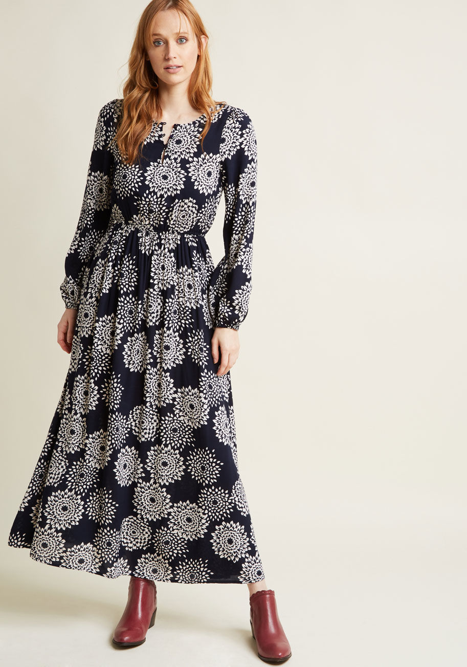 131538A - The vibe given off by this navy blue maxi dress is just so darn positive! Simple, yet anything but basic, this ivory-dahlia-printed gown - a ModCloth exclusive - flaunts three shiny buttons at the neckline, flexible elasticization at the waistline and lon