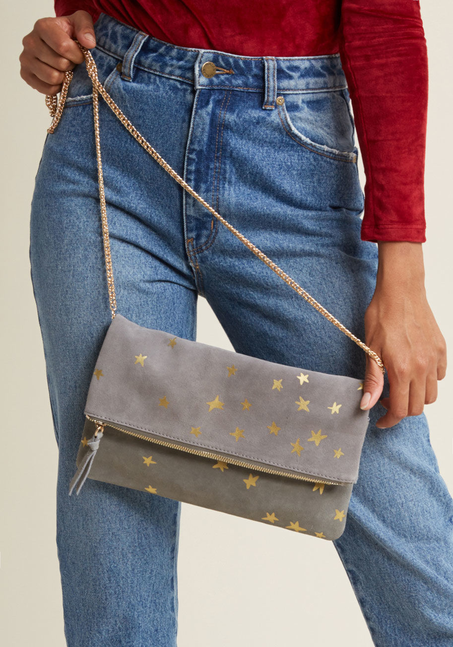 14420ML - MODA LUXE STYLE - With this suede clutch tucked under your elbow, you'll show up to the party whenever you're meant to! Sparkling gold stars spangle the grey foldover silhouette of this delightful purse, which safely zips closed and offers a crossbody chain strap for alter