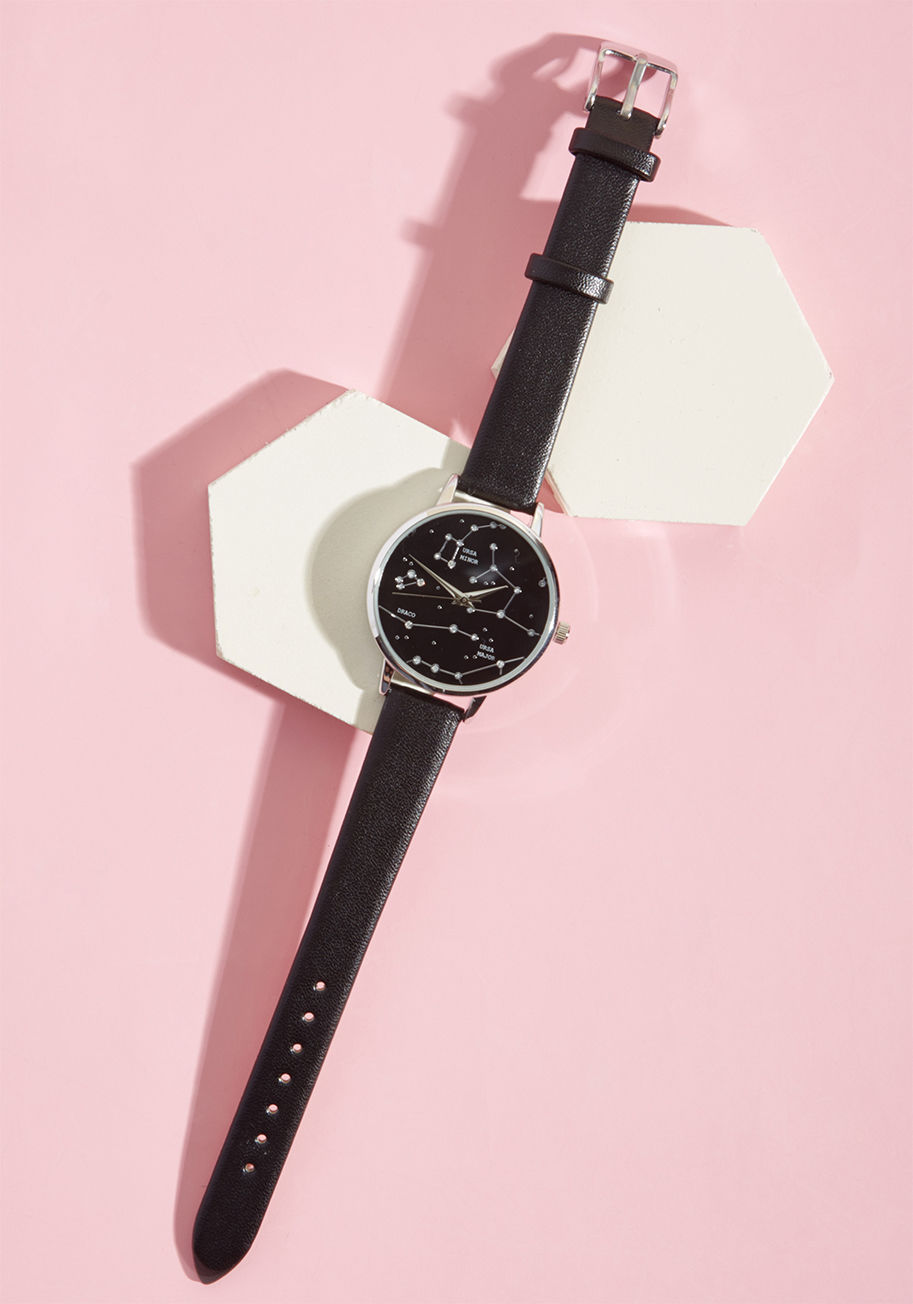 15260 - Now you can keep track of time and space by adorning your wrist with his delicate silver watch. A black, faux-leather strap acts as the perfect support for the rhinestone-touched constellations Ursa Major, Ursa Minor, and Draco that drift across the midni