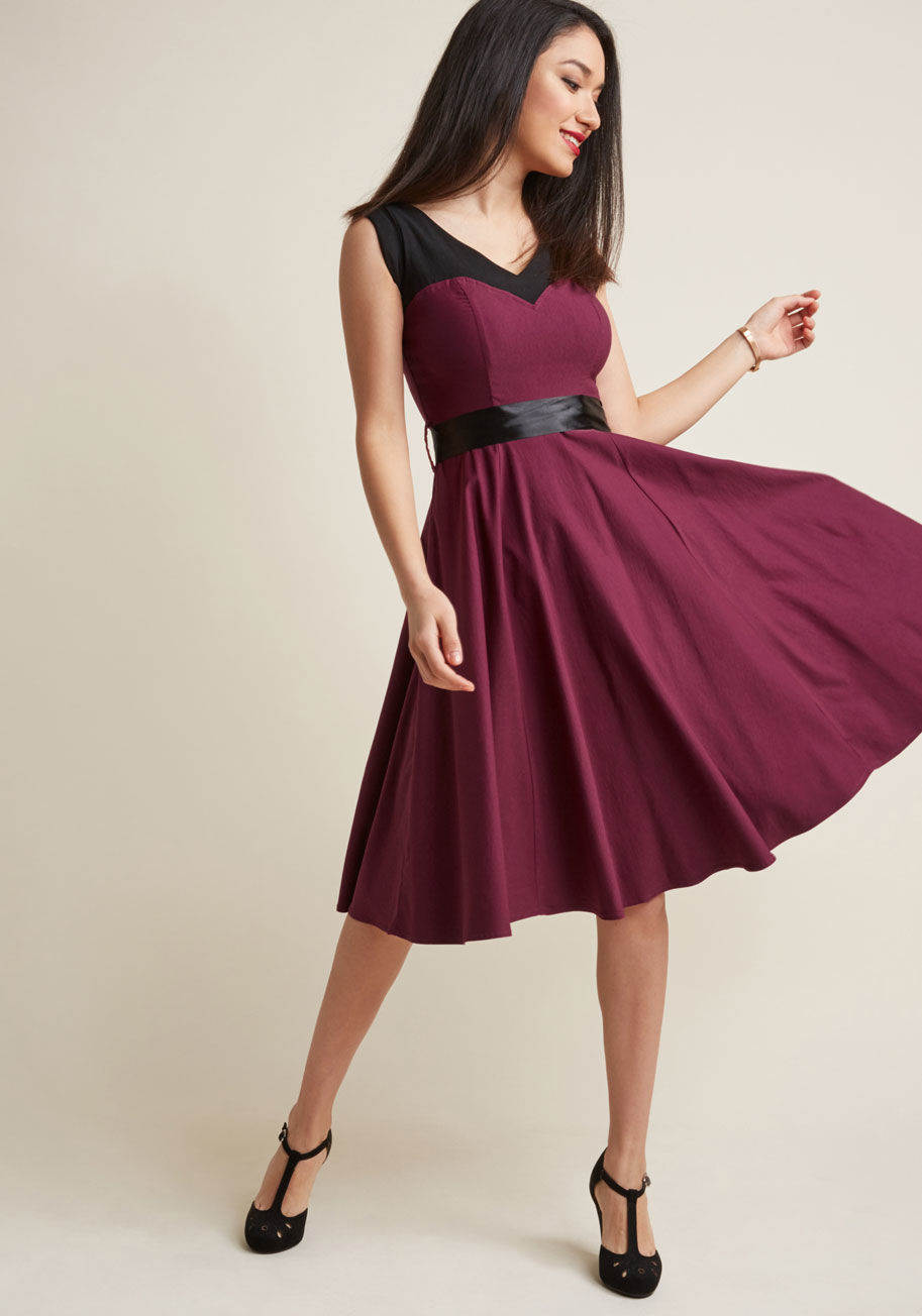 17454 - Styling this pinup-inspired dress can only end one way - with marvelousness woven throughout your evening! Boldly colorblocked with black shoulders and a fuchsia body - meeting at the sweetheart neckline - this swingy, ribbon-sash-tied frock is the quicke