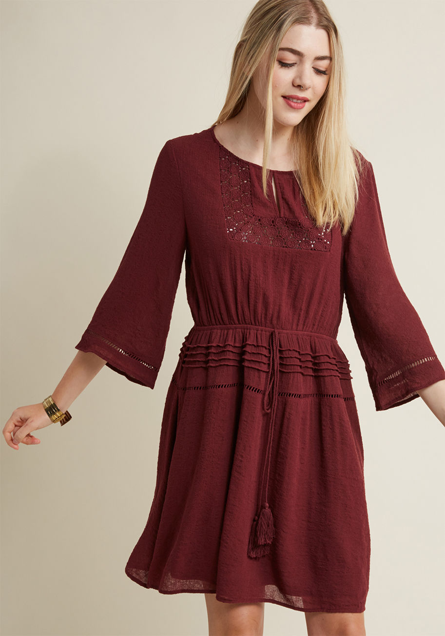 24104D - Browsing produce booths has never looked nor felt as beautiful as it does while donning this bell-sleeved dress! Flavored with boho-inspired touches like a crocheted yoke-framed keyhole, a tasseled tie-topped waistband, and a pintucked skirt, this crepey 