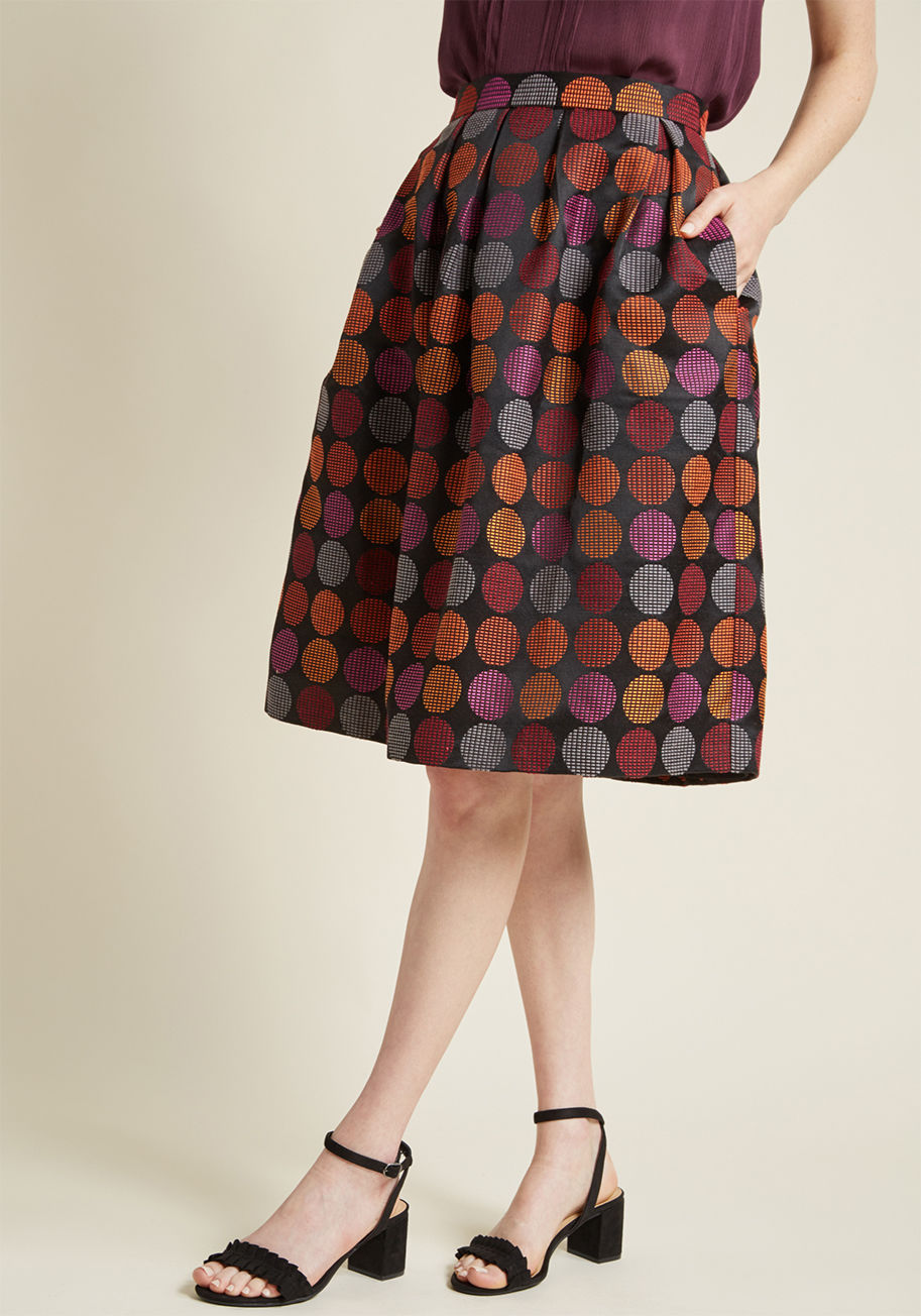 3143 - Just when you thought there was nothing better than a black midi skirt, this fun fit and flare appears with its colorful dots and jacquard fabric! Further finessed with a high waistline, a pair of pockets hidden amongst its pleats, and a palette of orange