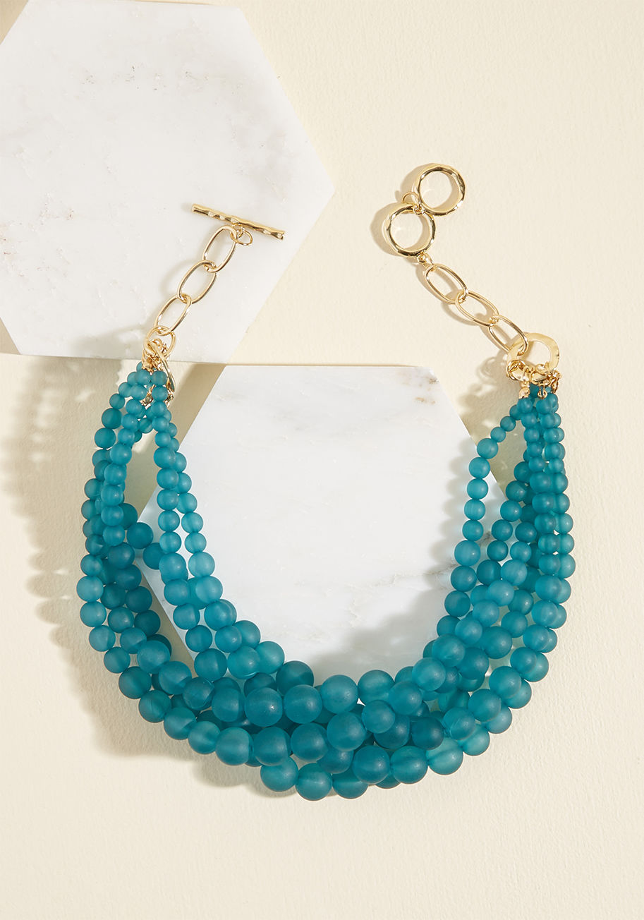 406899N-424 - Everyone will be amazed with your fashion finesse when they witness the addition of this teal necklace to your ensemble. Strands of matte beads twist together between sections of golden open-link chain to create this statement-making accessory that just m