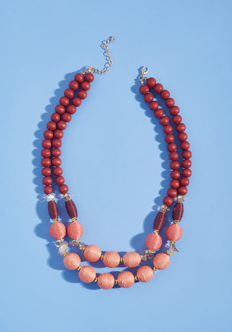 451075N-204 - With the simple addition of this beaded necklace, you take your look from sweet to complete! Dual strands of blush, peach, and burgundy beads add texture and intrigue to this eye-catching accessory, as its gold accent hardware provides the perfect touch o