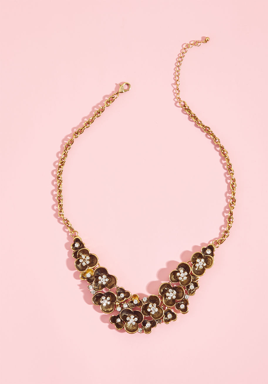 455178N-001 - The fabulous finishing touch to your fancy ensemble? Done! This antiqued gold necklace features rhinestone-encrusted flowers suspended by a classic cable chain, aka exactly what you need from a formal accessory. Boom.