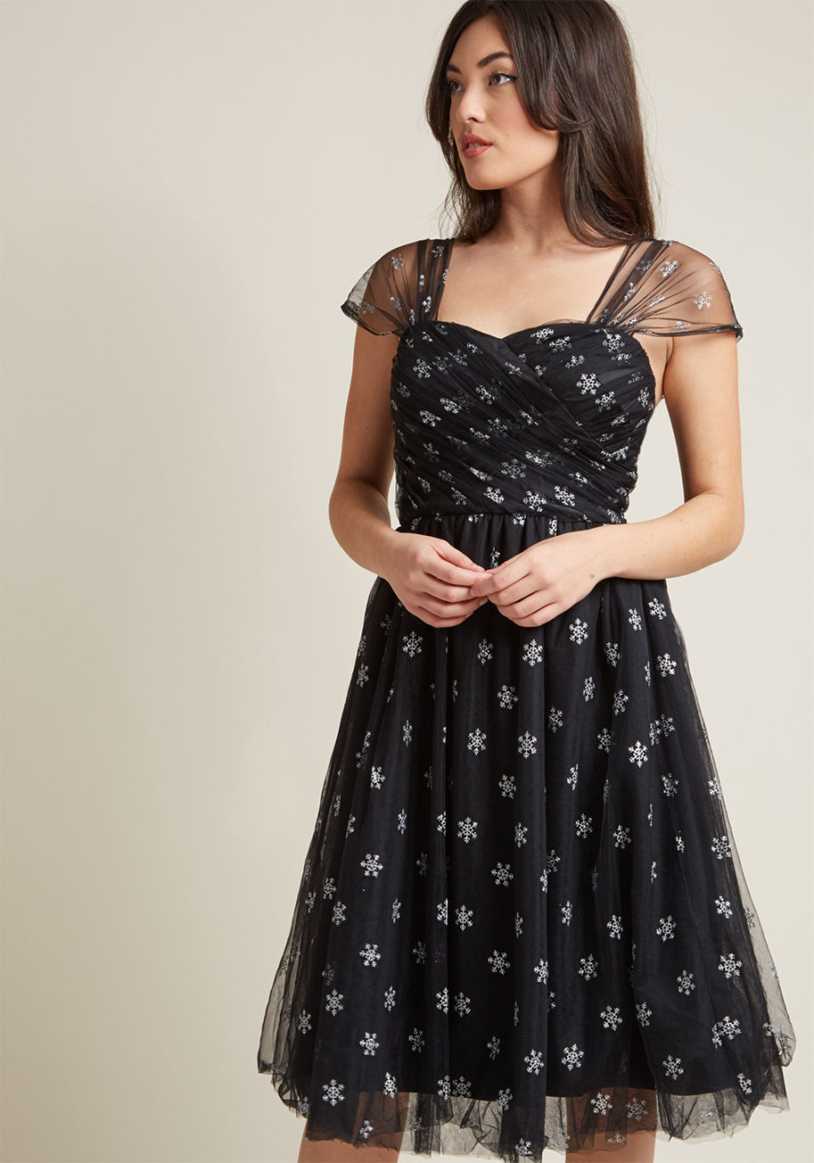 4772 - Whether or not the flurries have started to fall, it's time to expand your wardrobe to include this black dress from Hell Bunny. There's no limit to the ways the cap sleeves, ruched sweetheart bodice, and glittery silver snowflake embroidery of this dress