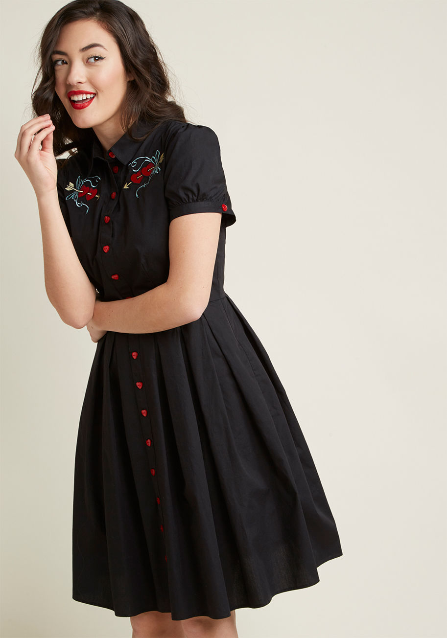 4803 - When it comes to romantic garb with a retro twist, this black shirt dress is obviously your most glam option. Dolled up with puffed short sleeves, love-themed chest appliques, and heart-shaped buttons, this cotton Hell Bunny frock is full-on fab. Plus, it