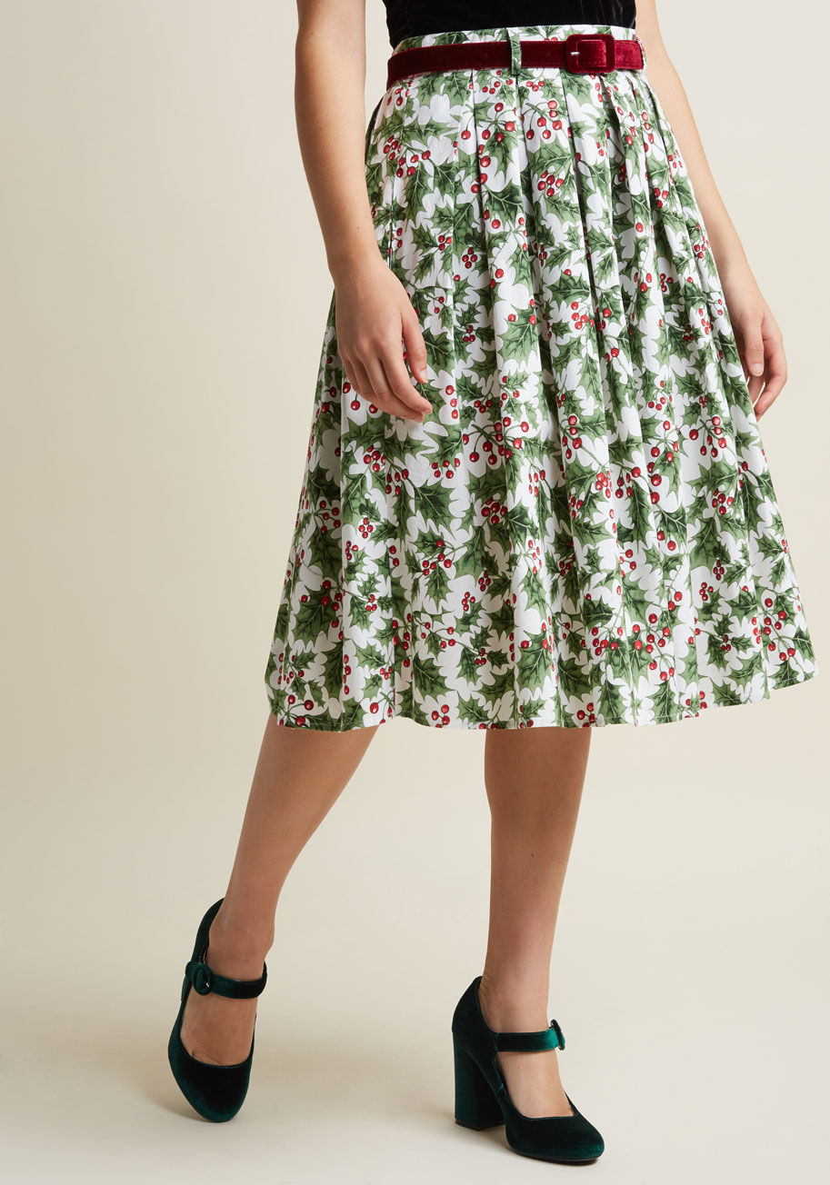 5447 - Exclamations for the festive nature of this white midi skirt are inevitable! A vintage-inspired find from Hell Bunny, this cotton A-line - with its velvet belt atop hidden pockets and green-and-red holly print - declares itself as your holiday spirit swee