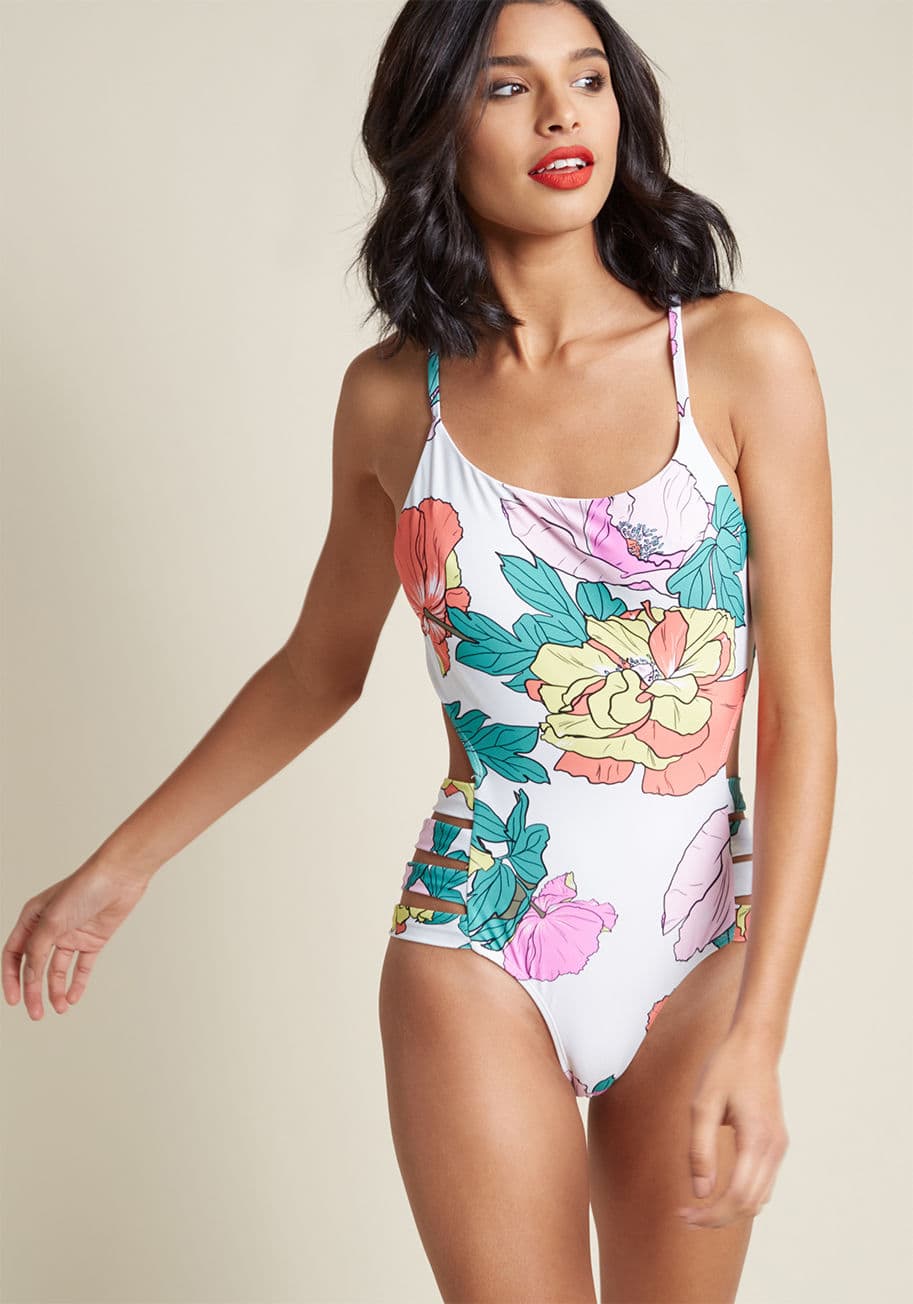 6850 - Starting from the moment you slip into this white swimsuit, your every status update will be beach-themed! Painted with colorful florals and fronds, containing crisscrossing straps that tie