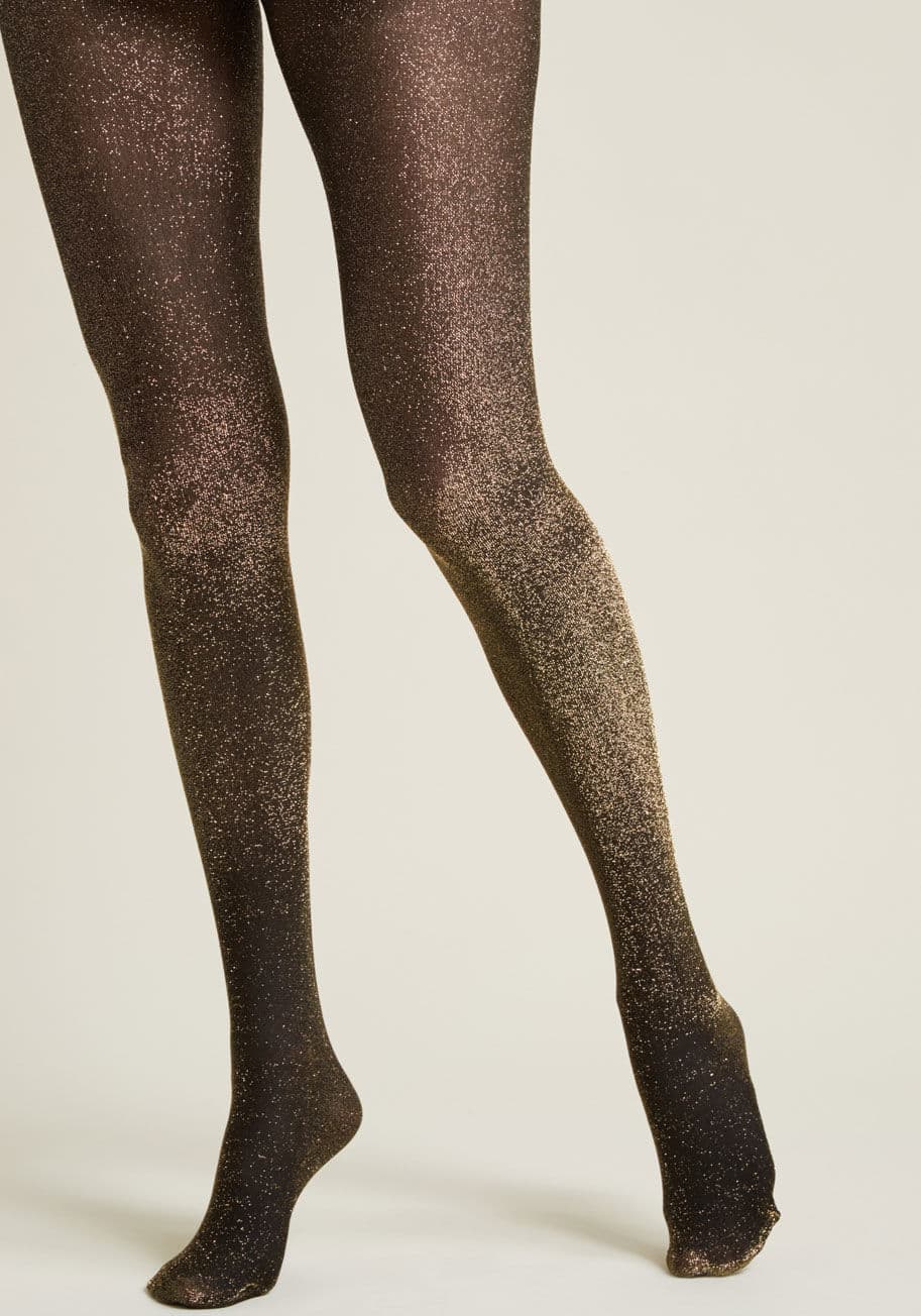 7120 - Your reaction when friends suggest you add sparkle to your ensemble? Bring it on! And, these sheer black tights are one wowing way to do just that. Infused with sparkly gold threads, this statement-making legwear is luxe and lovely!