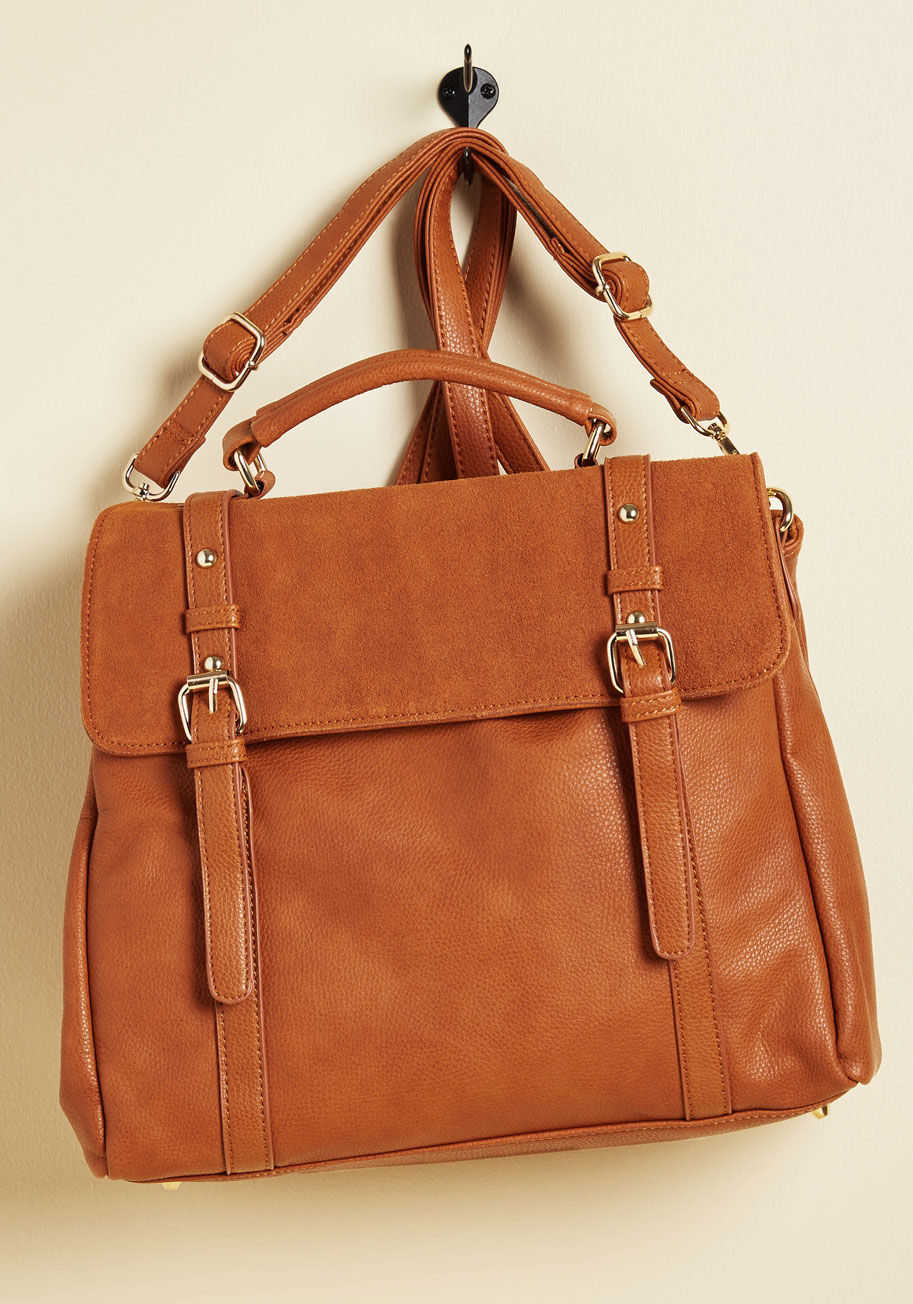 8062 - Can we all pause for a moment to appreciate the utter awesomeness of this rocker-chic bag? Equipped with two pocketed compartments, a suede flap that snaps shut, and the option to transform into a backpack, this cognac tan carryall is almost too cool to b