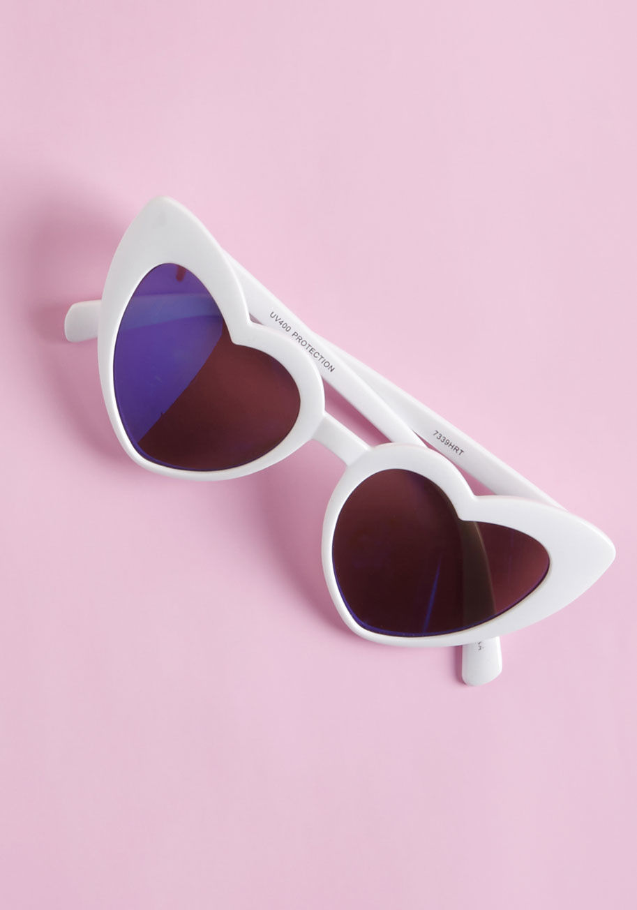 88476 - white - Polishing off your outfit with these heart-shaped sunglasses makes for a look that's sincerely sweet! Bright white frames hug the reflective blue lenses of this playful pair, and embrace your face with so much charm, it may just be 'amour' than you bargai