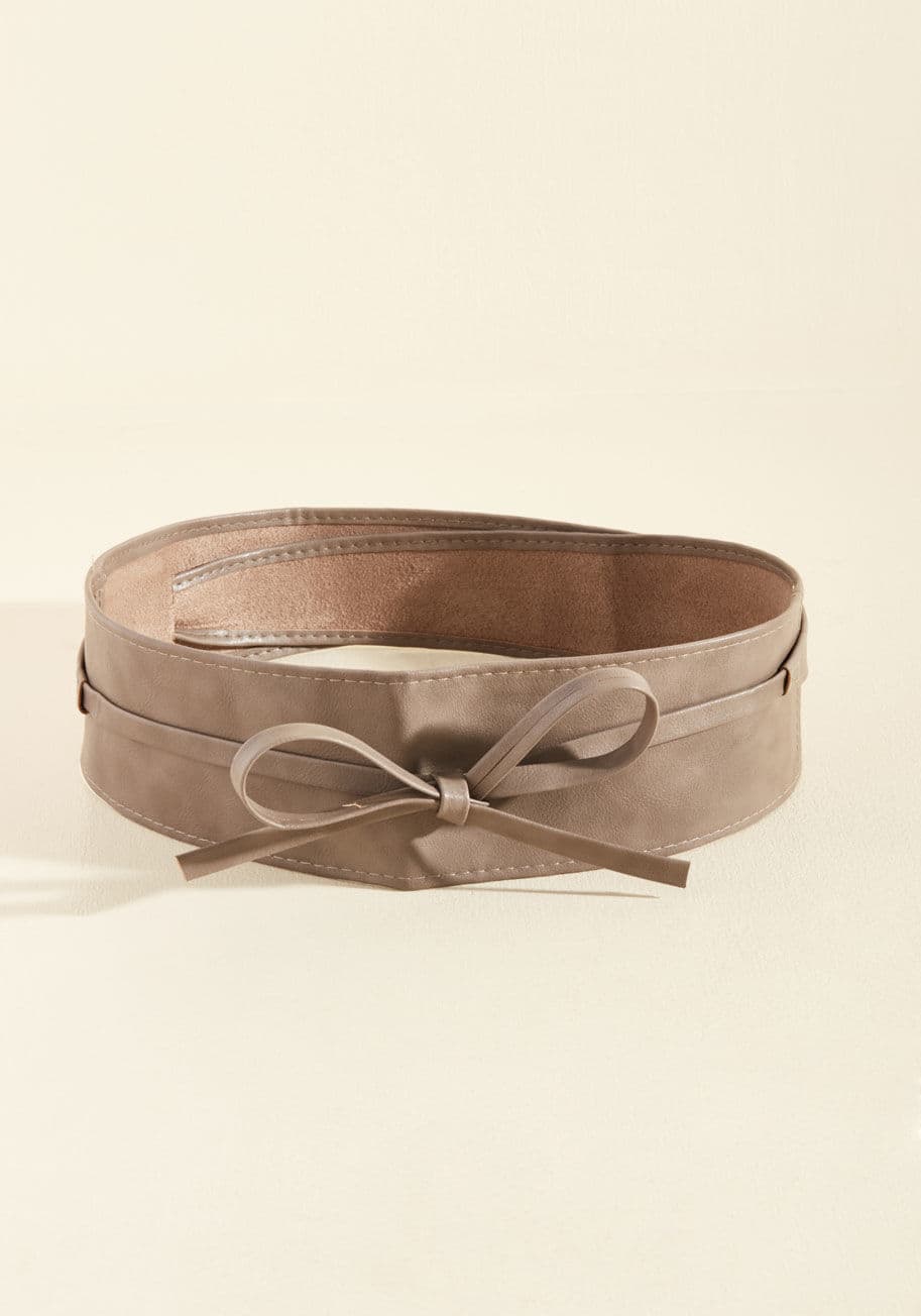 ABT5428 - Sport this taupe belt on the dance floor to help define your fab figure while you're twisting and twirling! This vegan faux-leather sash features a slit on the side, so you can wrap its ends through and tie them