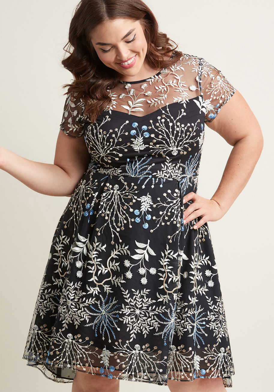 AP1D101294 - Infuse your upcoming event with magical moxie, courtesy of this black mesh dress by Adrianna Papell. The all-over embroidery of this sweetheart-neckline stunner features white, pale beige, and cornflower florals, while sheer shoulders and short sleeves te