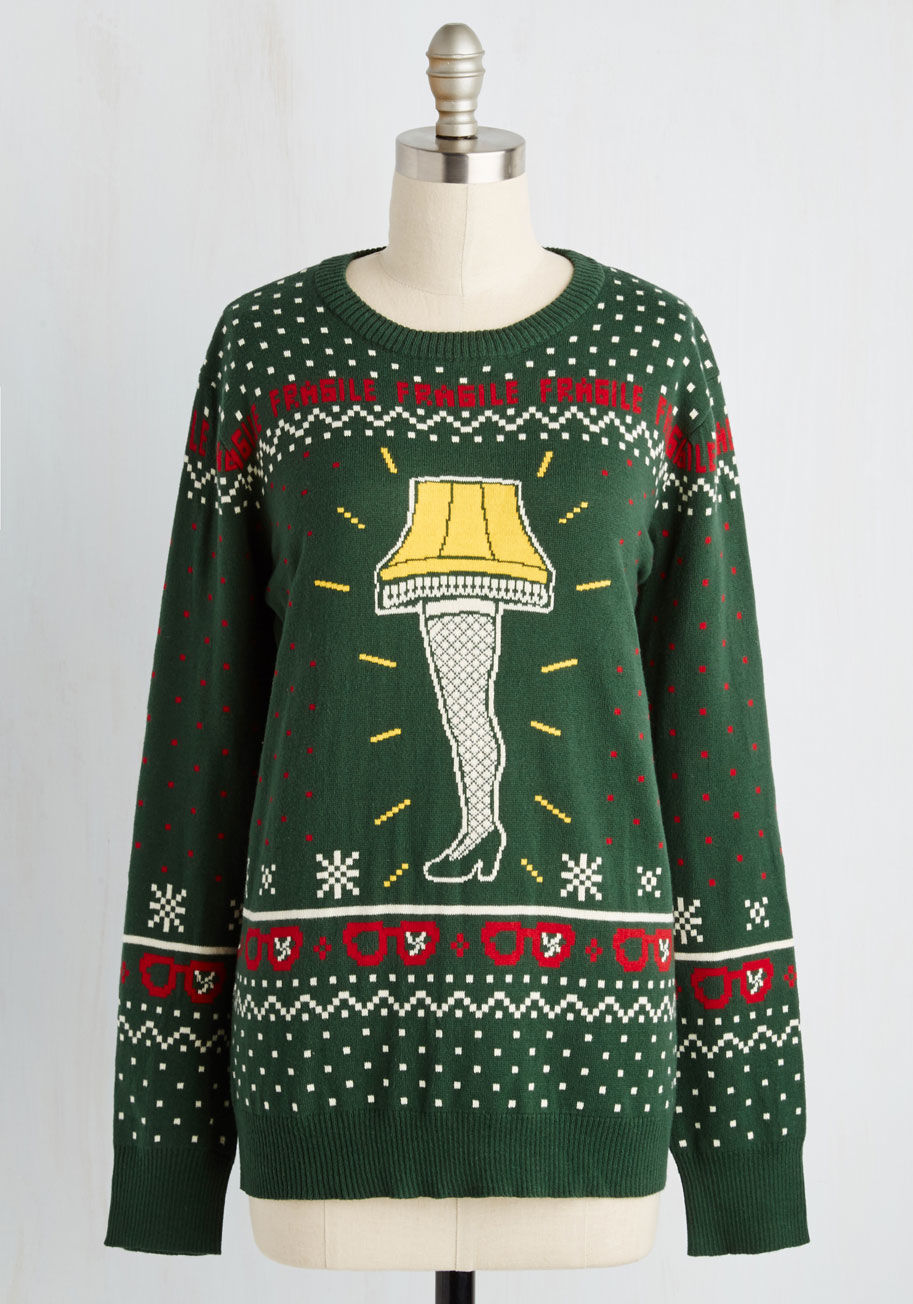 CSSM2147 - Get a leg up on holiday fashion with this pine green sweater! In a yellow, red, and white intarsia knit, this pullover stars the iconic lamp from A Christmas Story, a banner of &ldquo;fragile&rdquo; text, and broken glasses - just what 'yule' need to spre