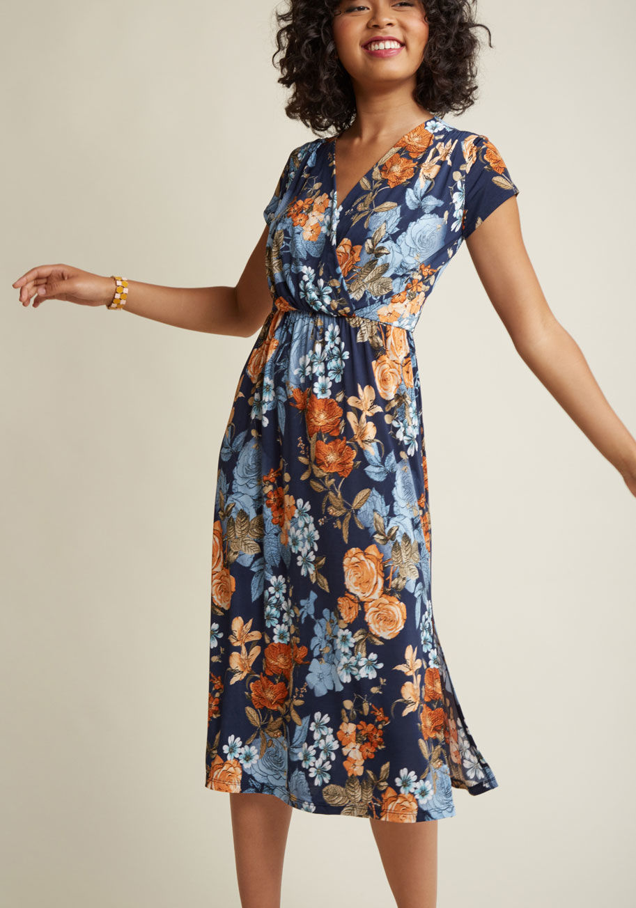 D12061-1 - Start your weekend off with a morning stroll wherein the sun shines down on this navy blue frock's cap sleeves and surplice neckline. The vent gracing its hem's left side is a chic touch that'll style your afternoon's museum visit to a T! And, when you ad