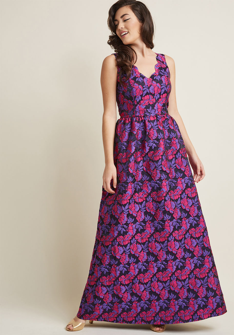 D61699 - The moment an elegant engagement appears on your calendar, so do visions of how you'll style this floral maxi dress! A ModCloth exclusive, this gown will wow the crowd with its scalloped V-neckline, vibrant purple-and-pink jacquard blooms atop a black bac