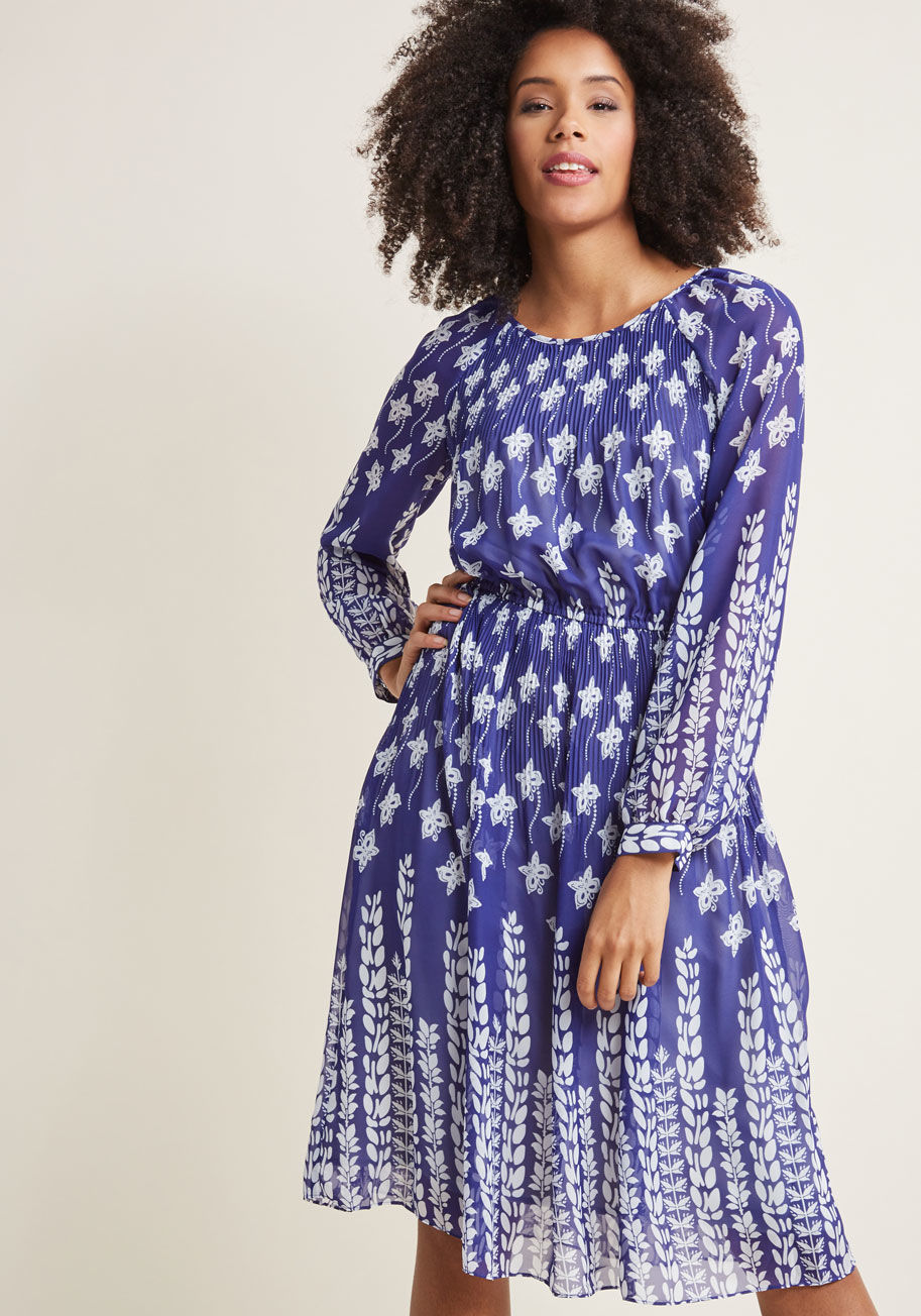 D61707 - Got a penchant for pleats? This blue dress is here to indulge such a charming trait, and do so much more. With sheer sleeves to keep you looking chic, a white print of butterflies and fronds for your delight, and of course, delicate pleating around the ne