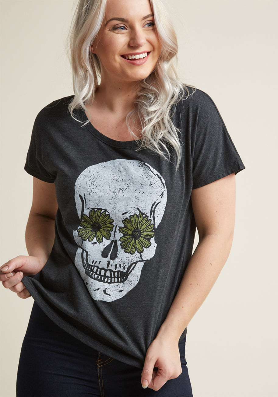 D6501 - When all you want is some R&R, but you still want to look your best, turn to this washed black tee! Detailed with a scoop neckline, seamless dolman sleeves, and a skull and daisy print, this boxy top is the perfect way to enjoy a day of well-deserved you-