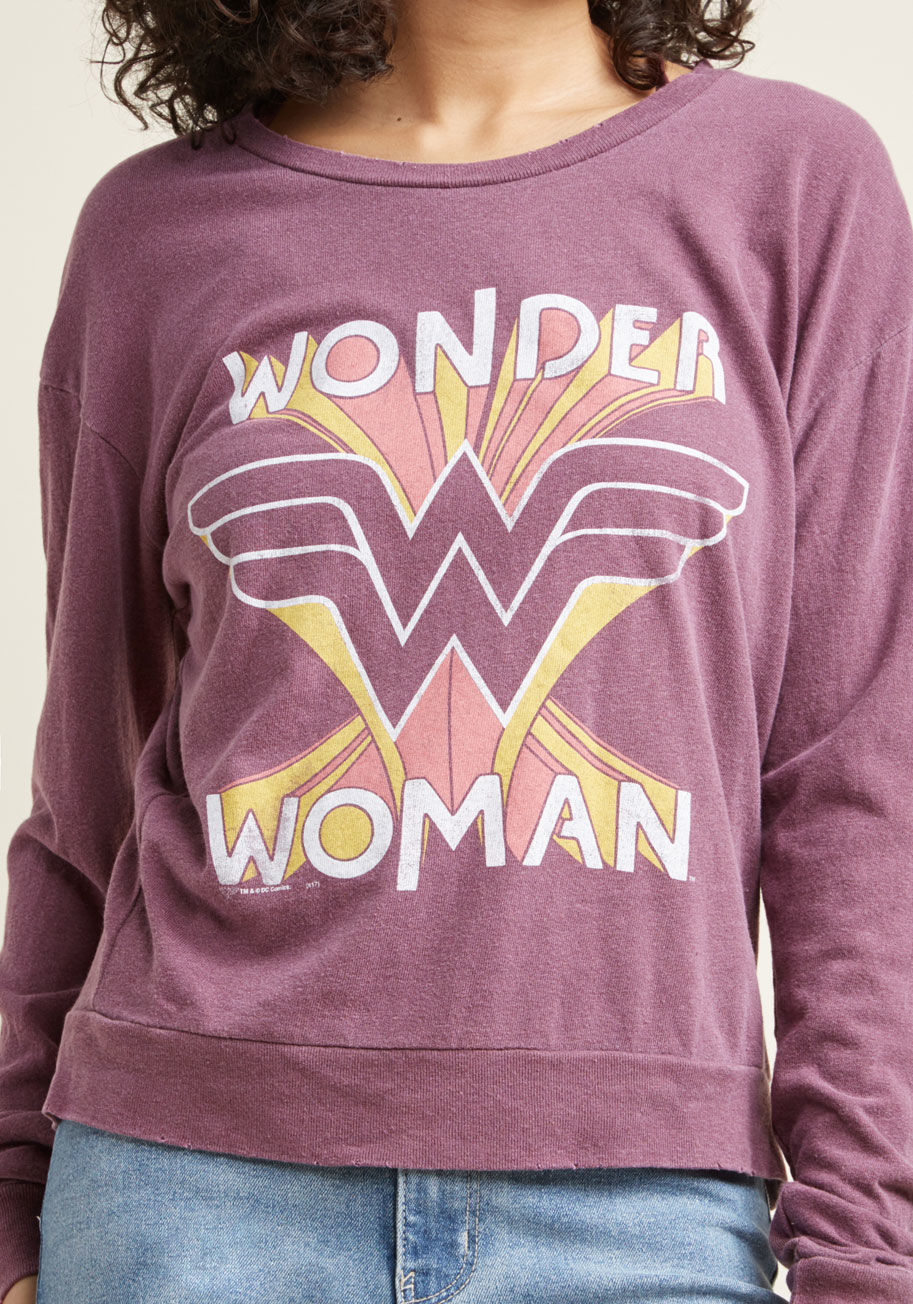 D8041-9001 - Though it's tough to acquire indestructible bracelets and a lasso of truth, it's simple to add this Wonder Woman top to your wardrobe! Projecting a message of confidence through its retro graphic atop lightweight fabric, this subtly-distressed, purple pul