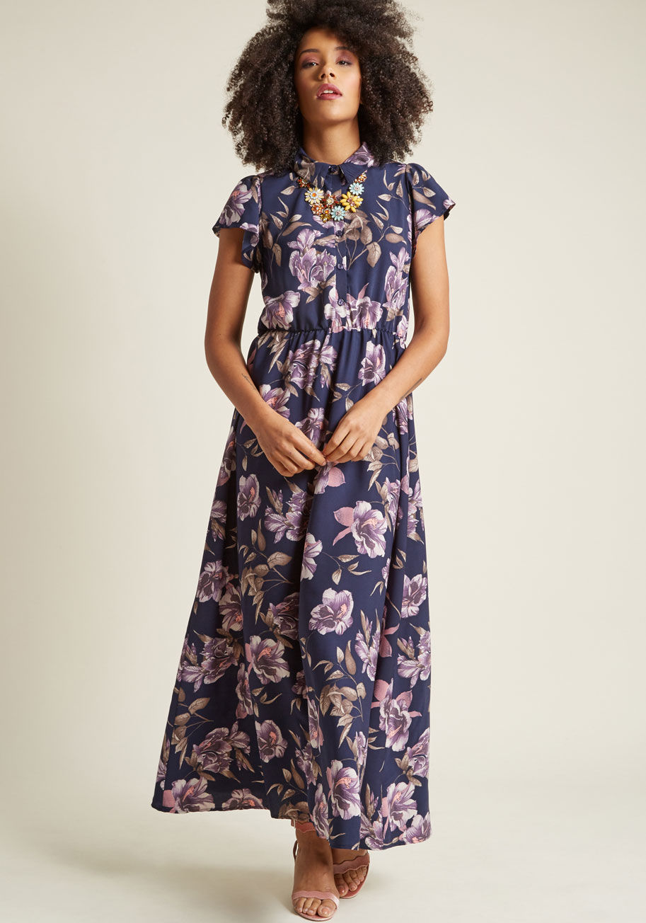 D855-01 - Will you debut this navy maxi dress at a casual outing, or save it for a more refined affair? The choice is yours! This ModCloth-exclusive frock can have its short sleeves, collar, buttoned bodice, and purple floral print styled any number of ways, so you