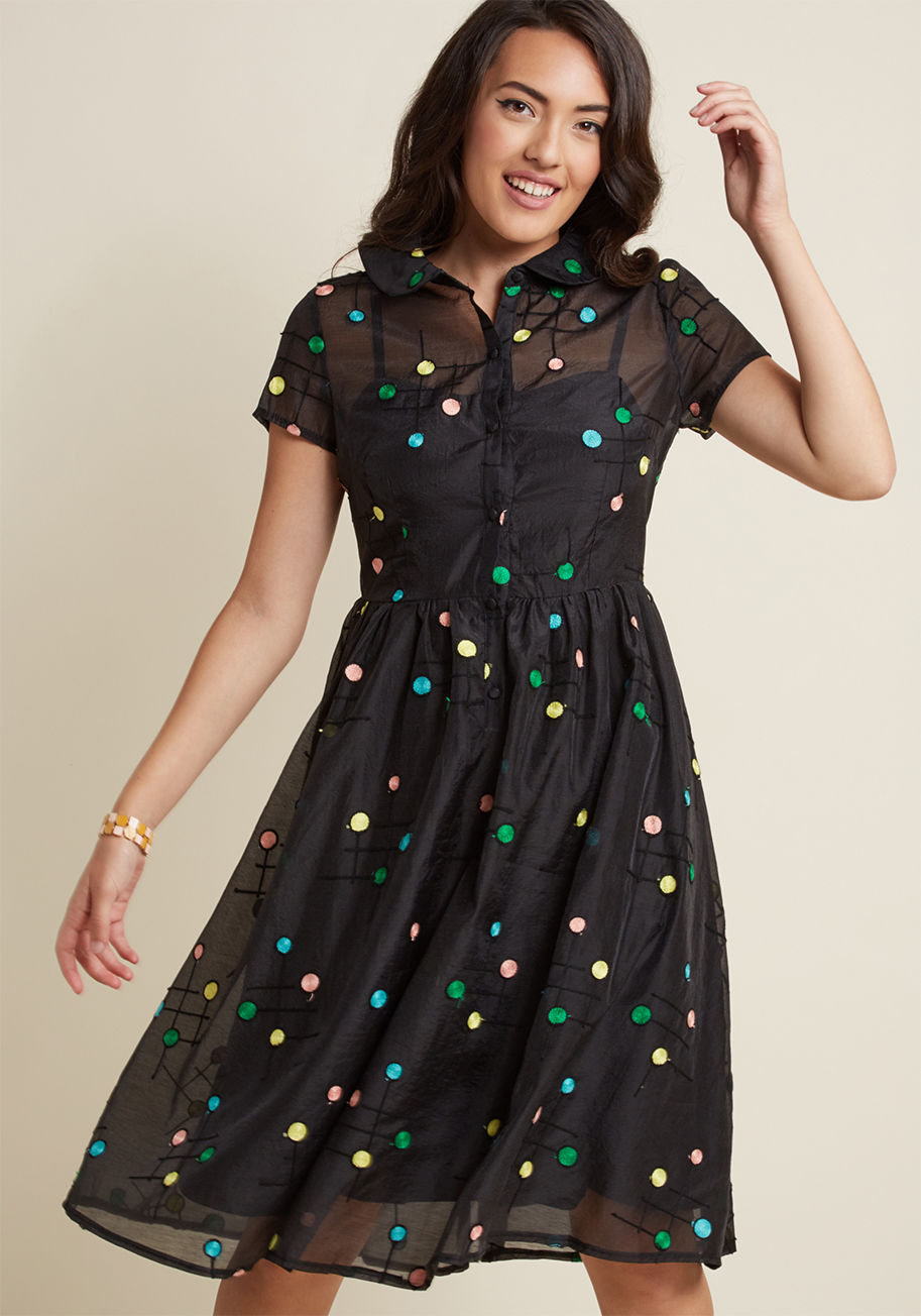 DRA8409 - Oh, the incredible difference a few colorful dots can make! On its own, this black shirt dress is simply darling with its short sleeves, sheer overlay, and midi length. However, the addition of yellow, green, pink, and blue embroidered spots transform thi