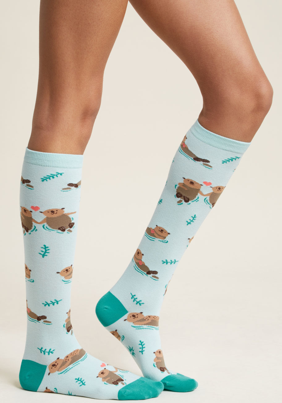 F0375 - These quirky knee highs require a double take - heck, maybe even a third or fourth review! Nobody expects to see socks printed with adorable, amorous otters floating atop a brilliant aqua hue, so if you find eyes staring at your stems, take it