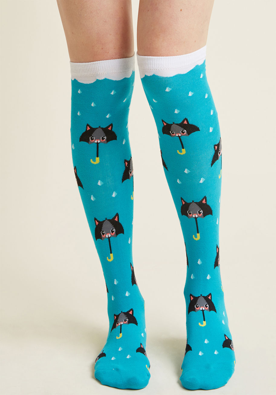 F0394 - Even when skies are cloudy, these aqua socks bring pretty of sunshine to your day! A print of black and grey, cat-shaped umbrellas cascade amid the raindrop pattern that details these knee highs, meaning compliments for their quirky look is right on the h