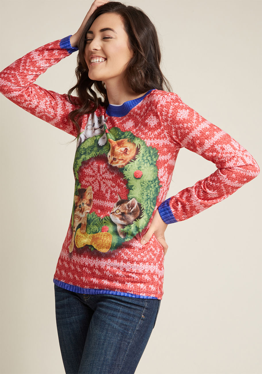 F133895 - 'Tis the season to be quirky, which you rep with this red graphic tee! A lightweight knit top fashioned to appear as though it's a classic red sweater topped with a kitten-rich wreath, this festive piece is the perfect pick for caroling, exchanging gifts,