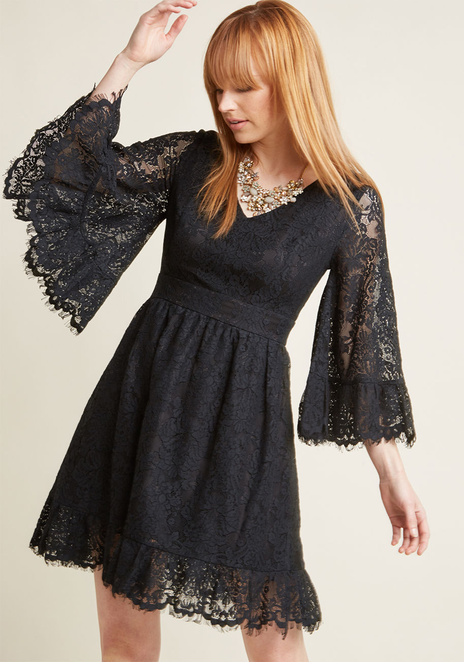 FA17MCD1395 - Your day off is dreamy as can be thanks to this vintage-inspired dress - part of our ModCloth namesake label! Flaunting the lovely lace overlay, V-neckline, and ruffled hemline of this black, bell-sleeved frock, you sway to a blossom-lined pathway nearby,