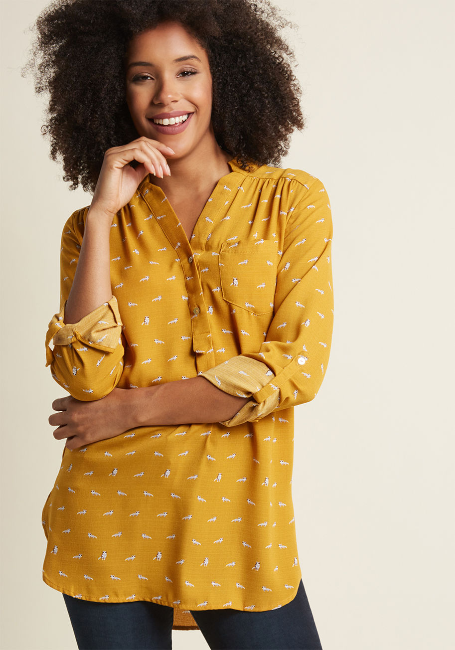 FD86882P - It&rsquo;s no surprise that this marigold top has become your favorite seperate. How could you not love the pleated shoulders, front pocket, and curved hem of this woven wonder? Top it all off with the adorable raccoon print, and this buttoned blouse is t