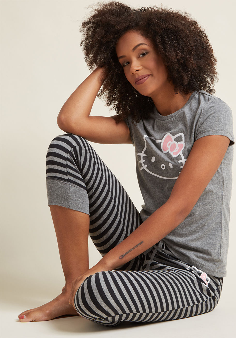 H82098 - Not every cat will snuggle up on the couch with you, but the Hello Kitty screen printed on these jersey knit pajamas sure will! Pairing a grey graphic tee with black-striped joggers, this cotton-blend loungewear is cute 'n' cozy. And, the drawstring waist