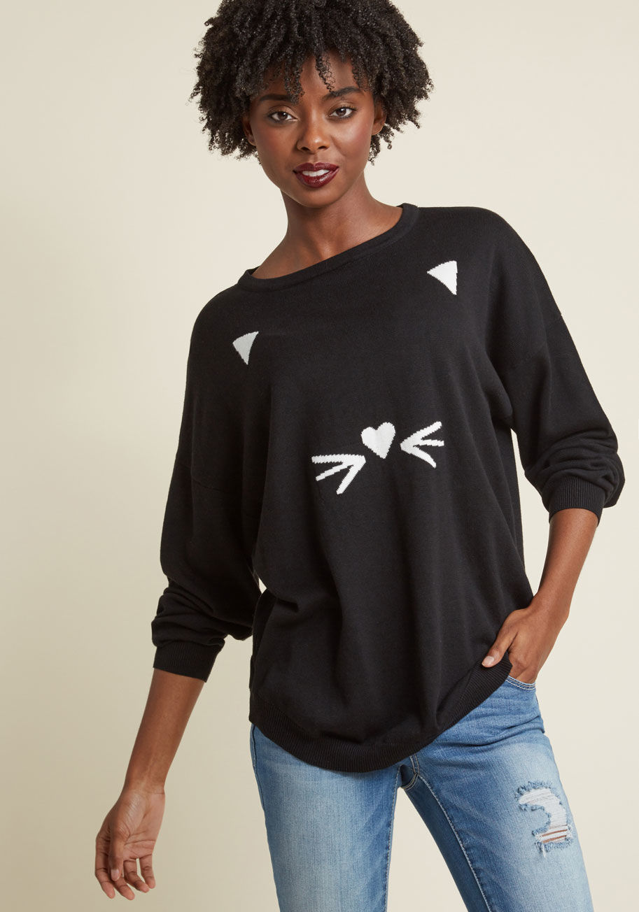 K0031-B - When it's late at night and the moon is bright, the black cat on your Sugarhill Boutique sweater might give you a fright! Just kidding, this roomy pullover is nothin' but cozy and its white intarsia ears, whiskers, and heart-shaped nose are friendly as ca