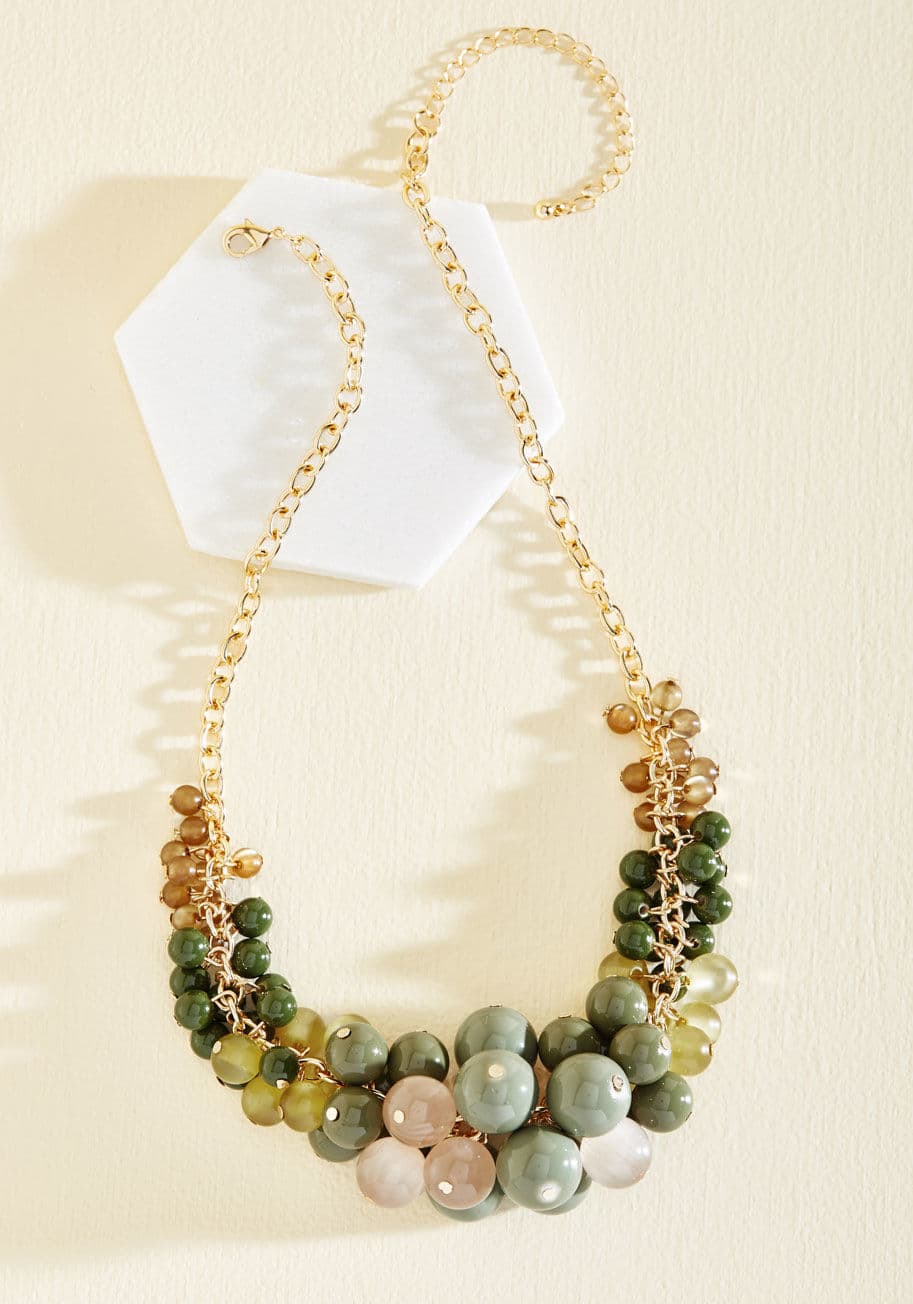 KGN18844 - Accessorize with this statement necklace and treat yourself to a day of complete enjoyment! Whether you find a new coffee spot or take a trek through the park, the lime, olive, and sage beads on this golden piece flounce with your movements. With this nec