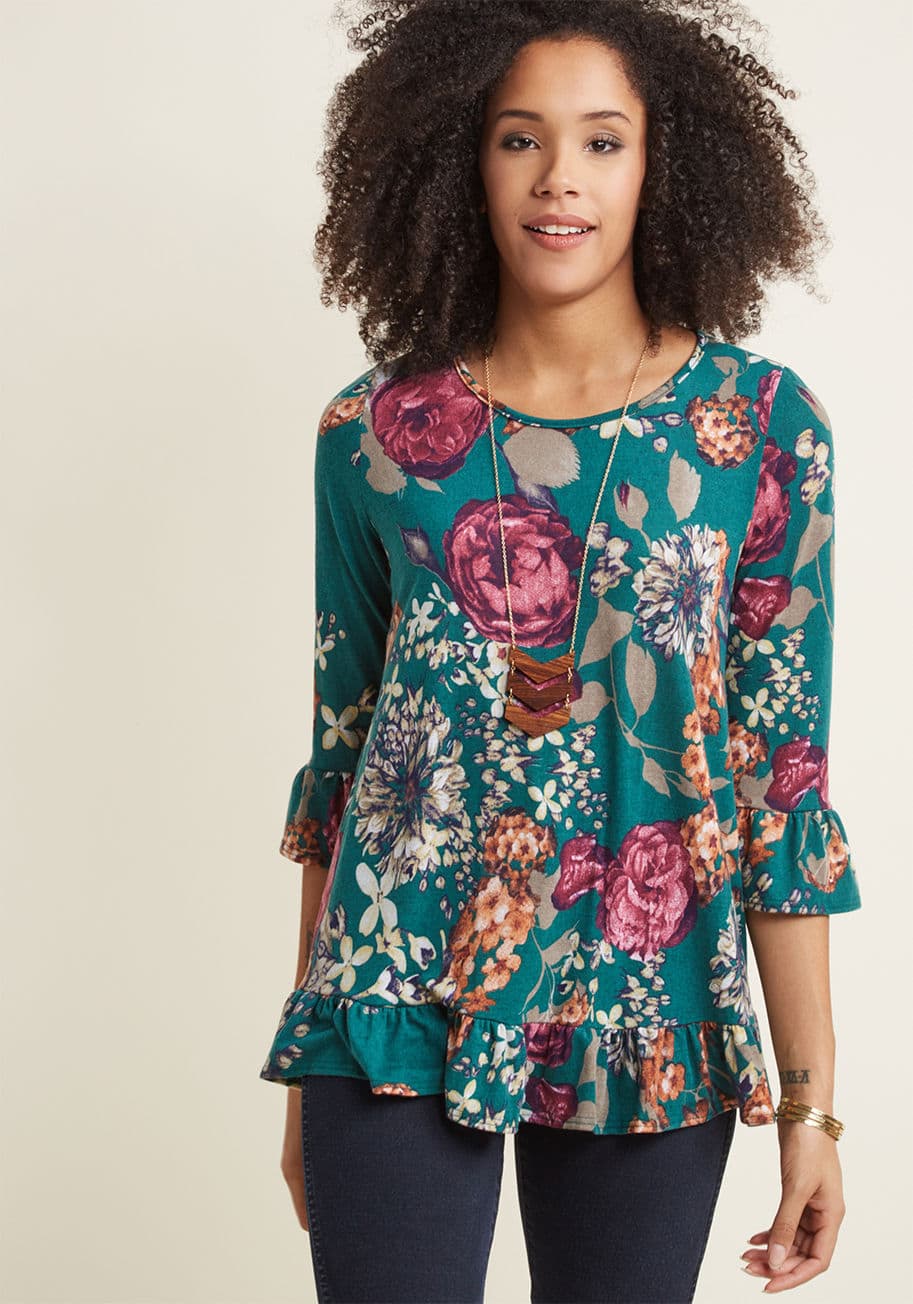 KT70965-02 - You'd gladly recommend this soft knit top to any friend looking for a floral separate! Made fabulously feminine with a muted berry, orange, sage, and navy flower pattern, ruffles at the 3/4 sleeve cuffs and hemline, and a swingy silhouette, this sweet shi