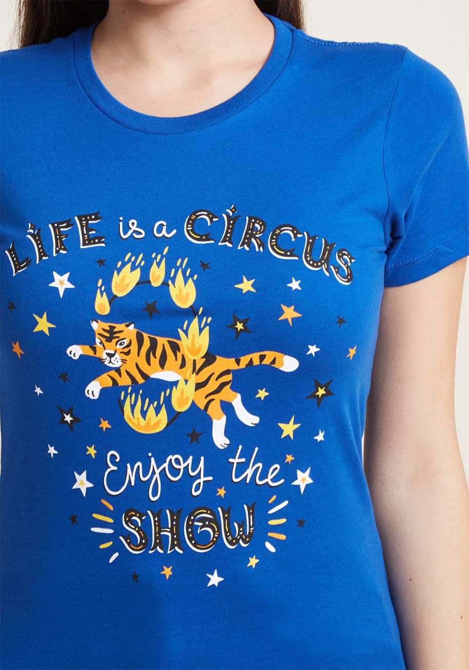 Life is a Circus - When life feels chaotic, let this royal blue graphic tee bring a smile to your face! A ModCloth exclusive featuring a screen print of a hoop-leaping tiger, a motivational quip, and black, white, and orange stars, this quirky crew neck is an inspiring styl