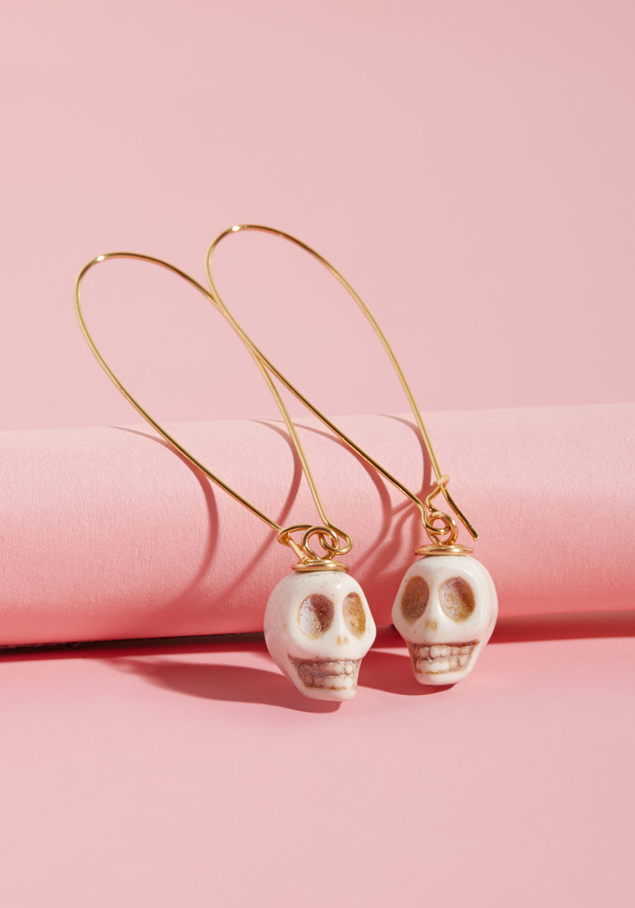 MC-HE-1 - With every compliment cast your way for these handmade earrings by Lenora Dame, you excitedly reply with gratitude! Subtle and elegant with their gold, drop-shaped frames, yet maintaining an air of edge with tan-speckled stone skulls at each end, this han