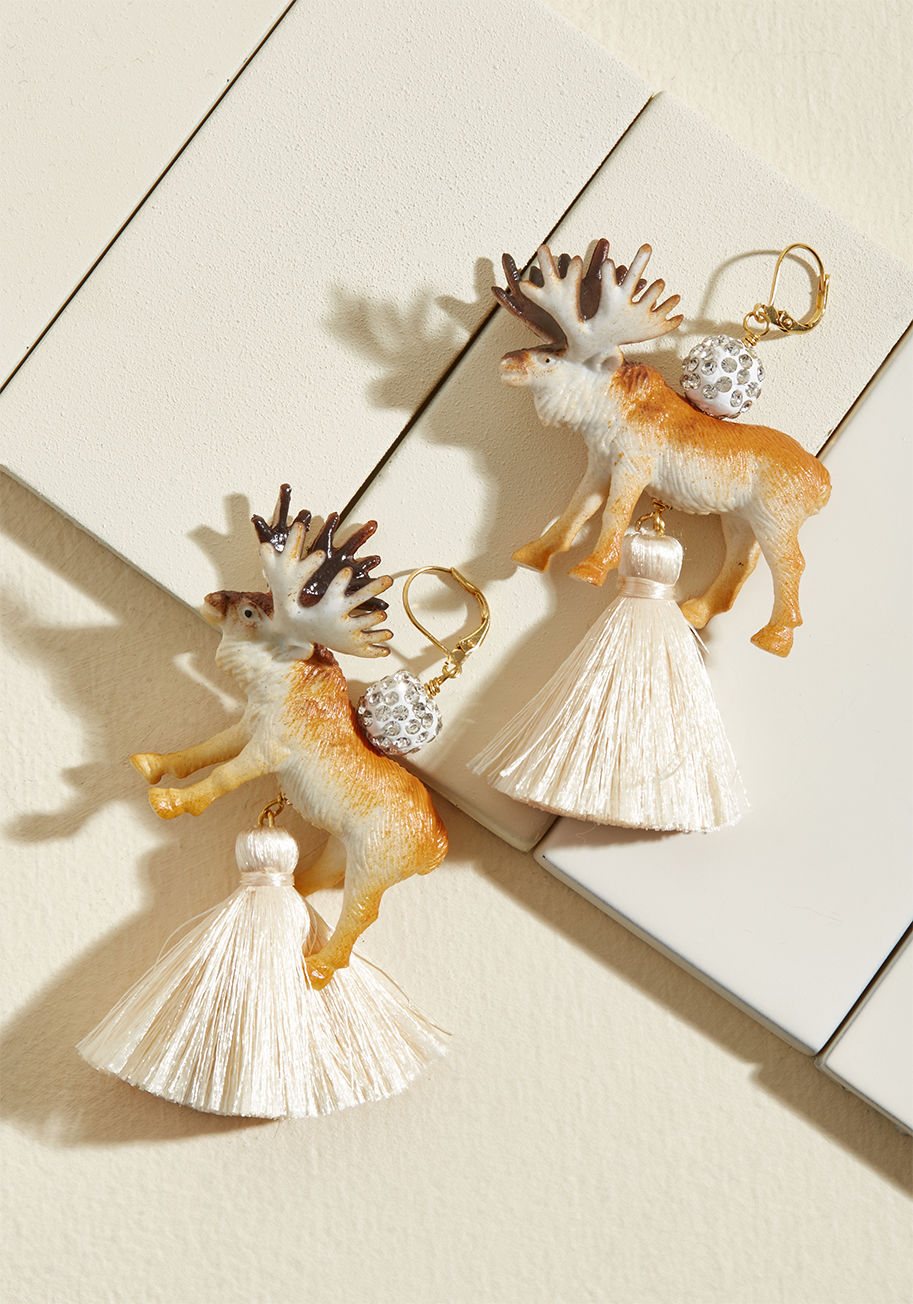 MC-HE3 - Looking for fun and fancy? Try on these hanging earrings from Lenora Dame! Boasting crystal ball details, rubber reindeer, ivory tassels, and 24-carat-gold-plated hardware, this duo provides a delightfully playful way to express your unique style!