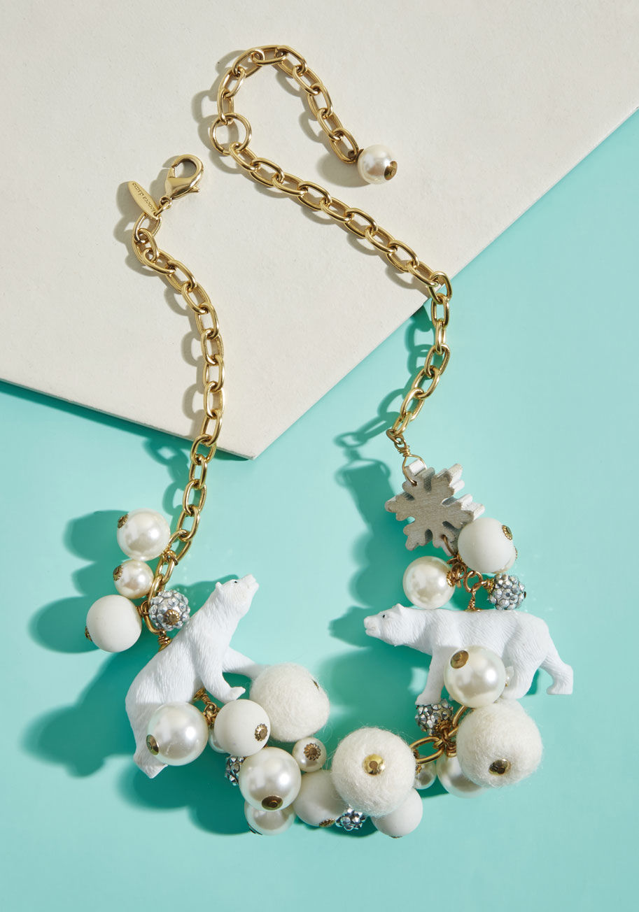 MC-HN-3 - Become the boss of all things frosty with this statement necklace from none other than Lenora Dame! A collection of snowflakes, shiny faux pearls, pom-poms, glittery beads, and polar bear figurines congregate atop the gold chain of this incredible accesso