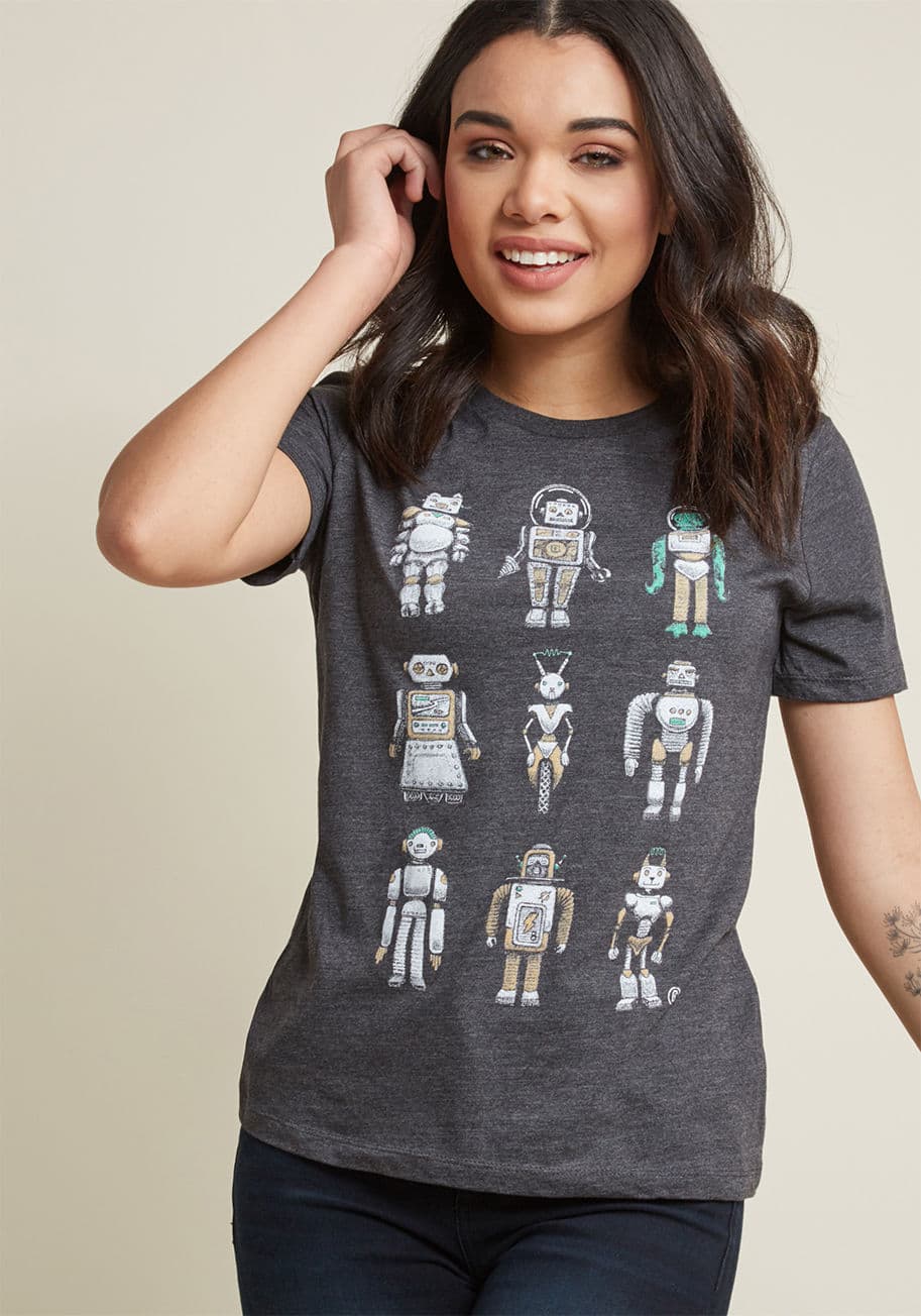 MC1175 - Show your support for the technological age by sporting this charcoal graphic tee. Detailed with a scoop neckline and a beige, green, and white robotic screen print, this casual top envisions a world where human, cat, and alien automatons live